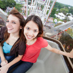 "Two young ladies on a ferris wheel high above suburban Chicago, Illinois"