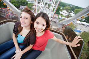 "Two young ladies on a ferris wheel high above suburban Chicago, Illinois"